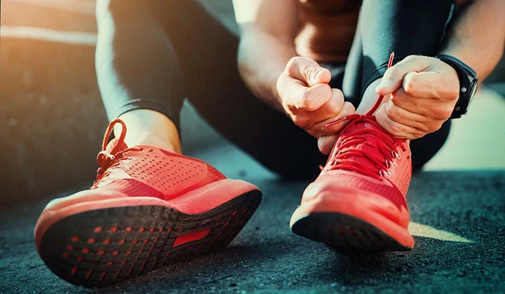 Sportler schnürt die Turnschuhe zu Vitaminmangel bei Sportlern
